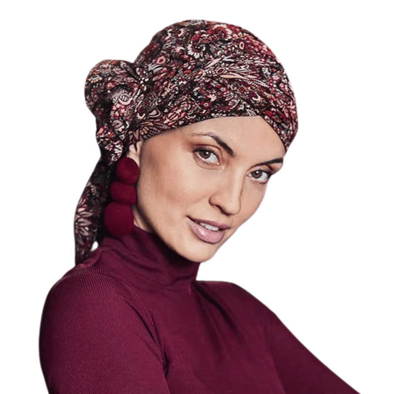 Kvinna bär Juvela turban Floral Folklore med blommigt mönster i rött och creme, sedd framifrån