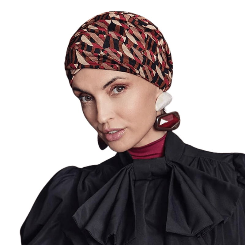 Kvinna bär en Sapphire Boho turban i Tribal Art-mönster med varma bruna och röda nyanser, sedd framifrån