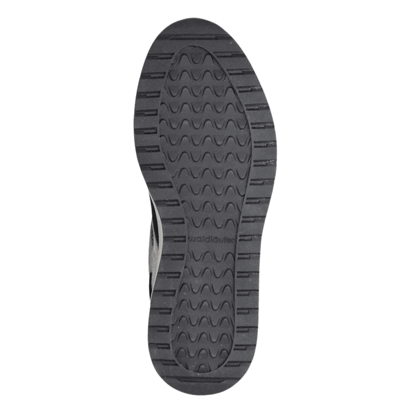 Svart sula på en Waldläufer damsneaker med vågigt mönster och text för bra grepp