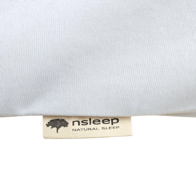Närbild av en textil etikett på det vita påslakanet, med en logotyp och text