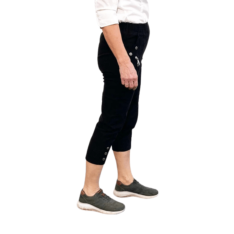 Sideprofil af klassiske sorte 3/4 Capri bukser med knapper ved benene båret af en person