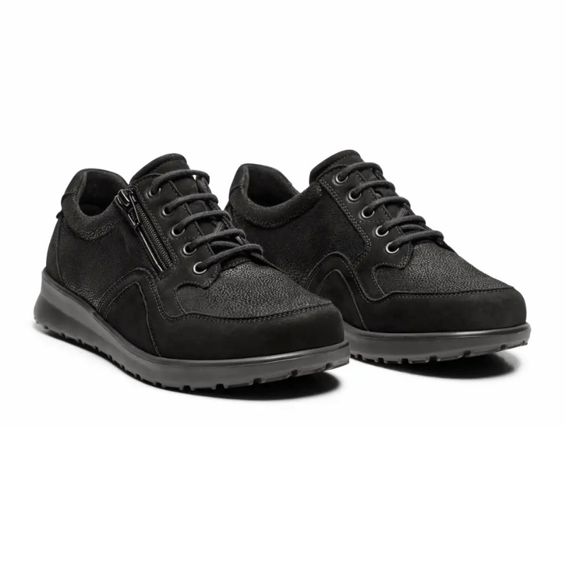Ett par svarta New Feet damskor i kalvskinn och textil med stretch, sedda snett framifrån