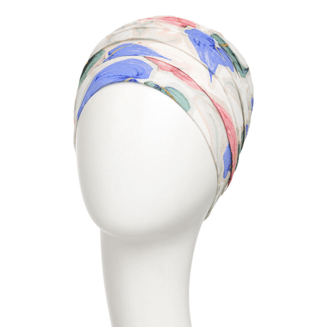 Yoga turban "Tropical blossom" med blå, rosa och gröna blommor på en vit skyltdocka, sedd från sidan