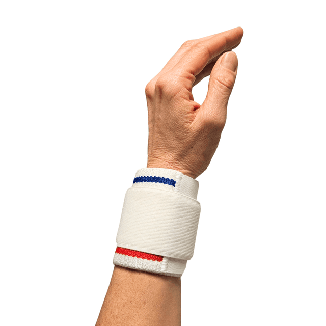 Vitt handledsstöd med blå och röda ränder, buret på en hand med fingrarna lätt böjda