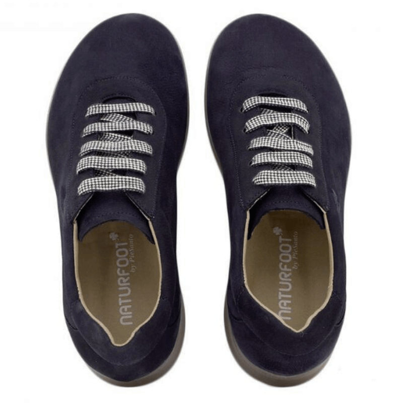 Ett par marinblå Naturfoot damsneakers i mocka, sedda uppifrån med snören och logga inuti