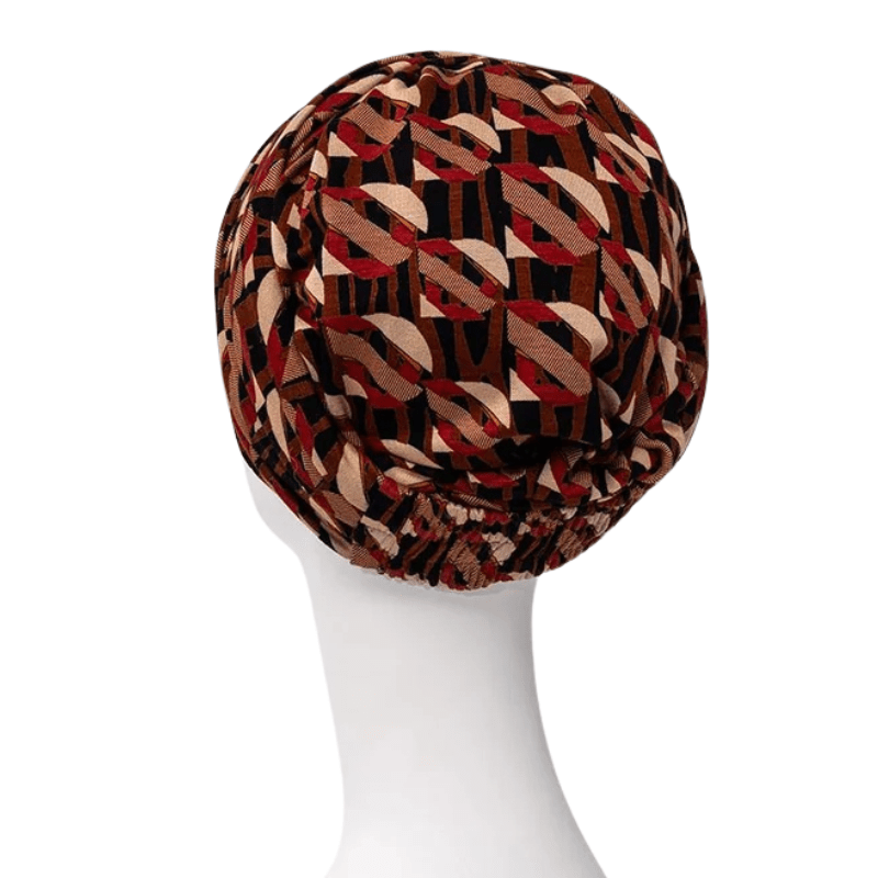 Baksidan av Sapphire Boho turbanen i Tribal Art-mönster, med synlig resår och varma färger på skyltdocka