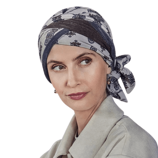 Kvinna som bär Beatrice turban med paisleymönster i grå och bruna nyanser, knuten i nacken