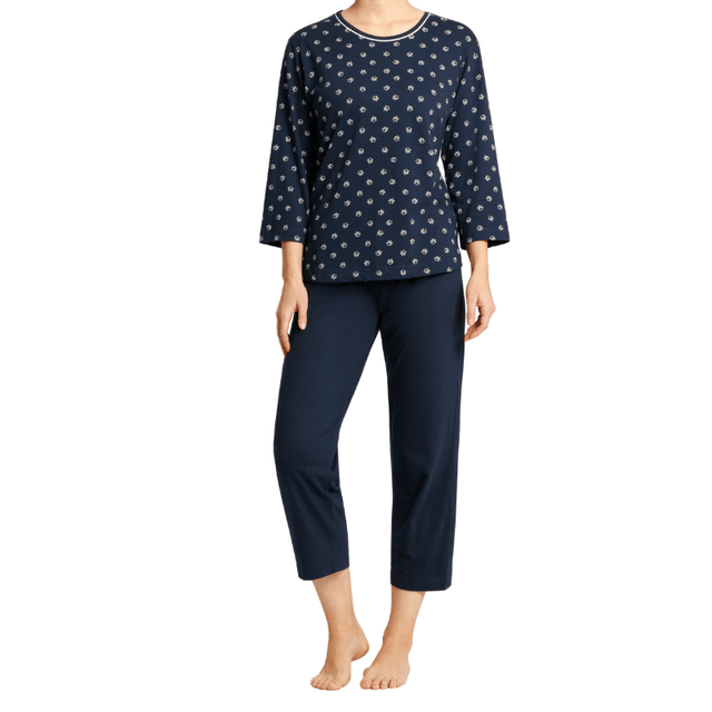 Mörkblå dampyjamas från Hajo med blommönstrad långärmad tröja och enfärgade 3/4-byxor, sedd framifrån på en kvinna