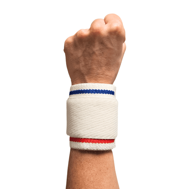 Handledsstöd i vitt med blå och röda detaljer, sett framifrån på en knuten hand