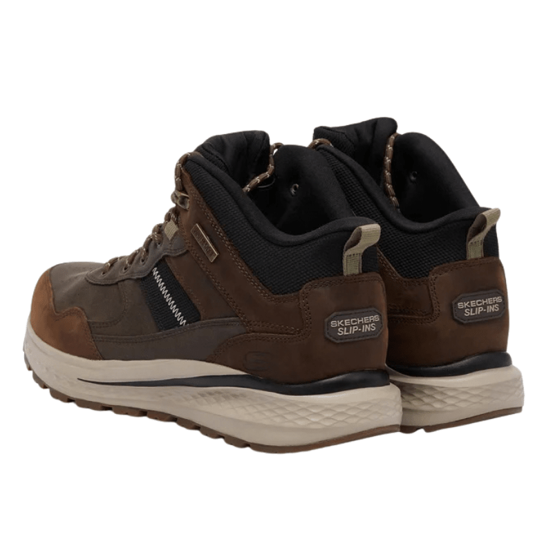 Bruna Skechers slip-in outdoor kängor för herrar, sedda snett bakifrån med slip-in detalj på hälen