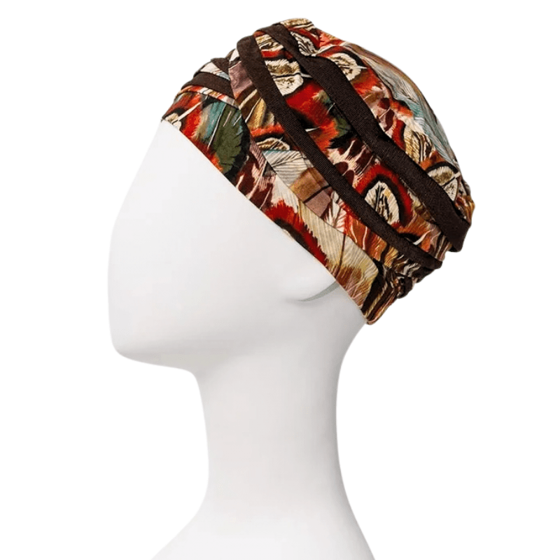 Shanti turban i Tribal Feathers mönster med fjädrar och linjer, sedd från sidan på en vit skyltdocka