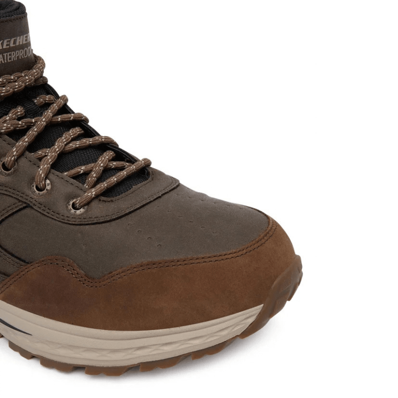 Närbild på tån och snörningen av en brun Skechers slip-in outdoor känga för herrar