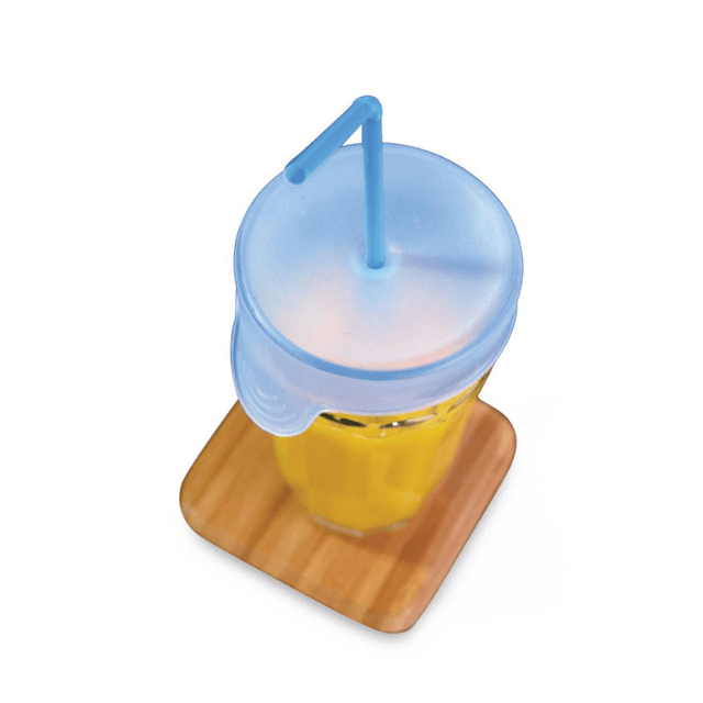 Ljust blått silikonlock på ett glas med orange dryck och ett blått sugrör, sett uppifrån