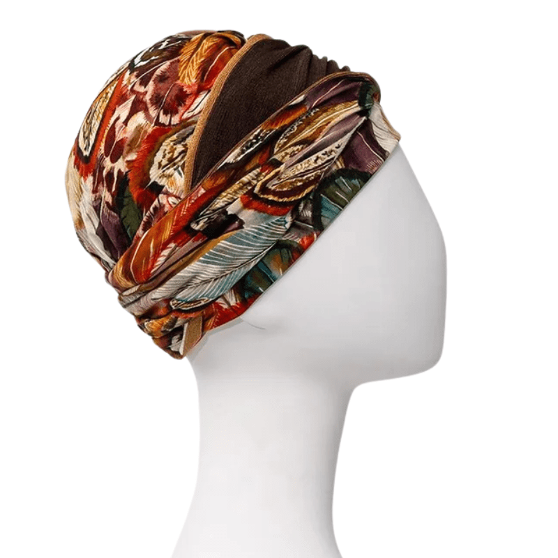 Shakti turban Tribal Feather med fjäderdesign i höstfärger, sedd från vänster sida på en skyltdocka