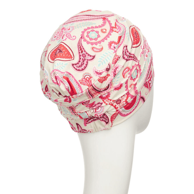 Yoga turban med paisley-mönster i rött och rosa, sedd bakifrån på en mannequin