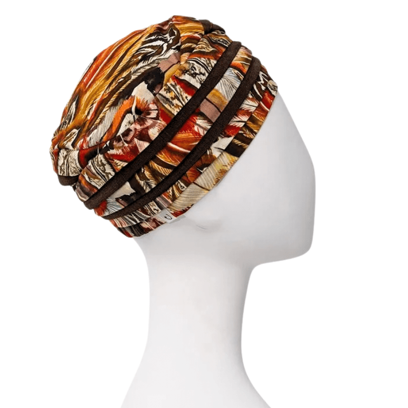 Huvudbonaden Shanti turban med Tribal Feathers mönster i höstfärger, sedd från andra sidan på skyltdocka
