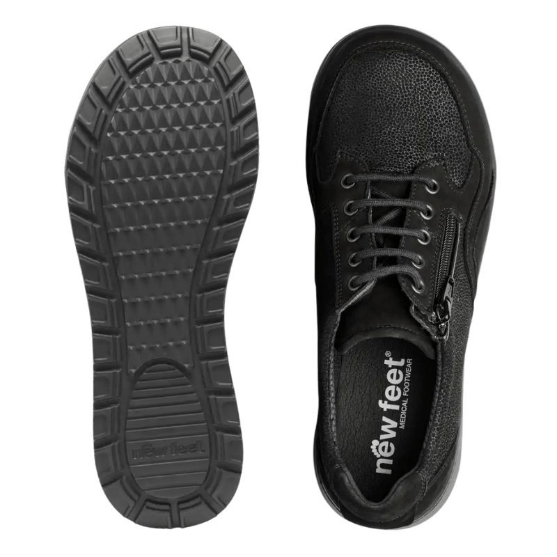 Ovansidan av en svart New Feet damsko med dragkedja och snörning, samt undersidan av sulan med mönster
