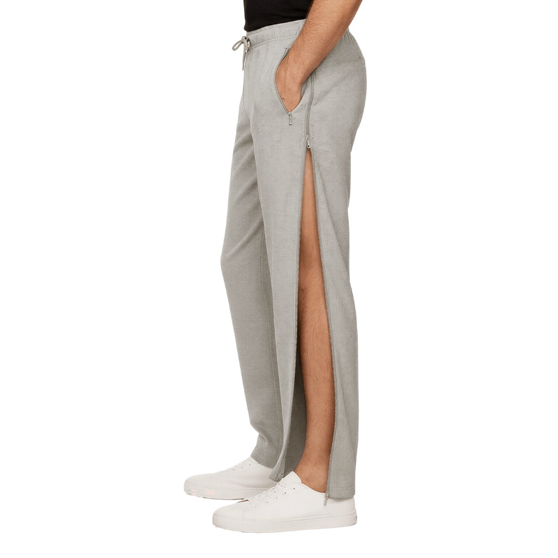 Grå sweatpants med dragkedja helt öppen längs sidan, sedda från sidan på en person