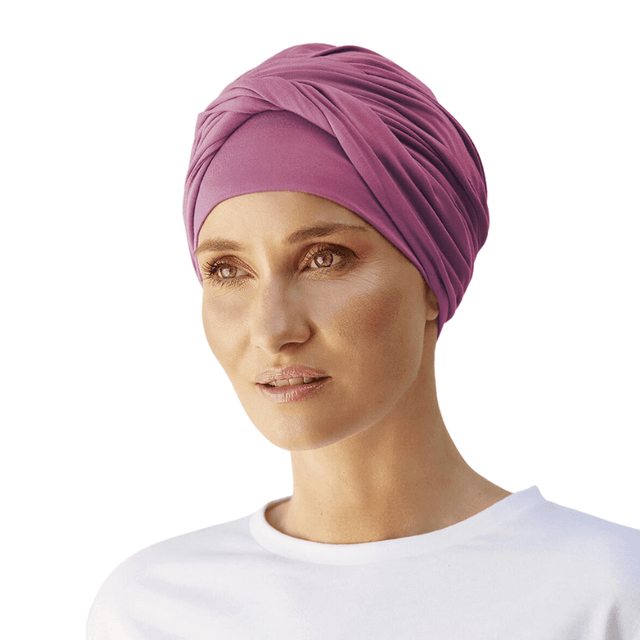 Kvinna bär en elegant Shakti turban i färgen rose wine, med vackra veck och en tvinnad detalj framtill