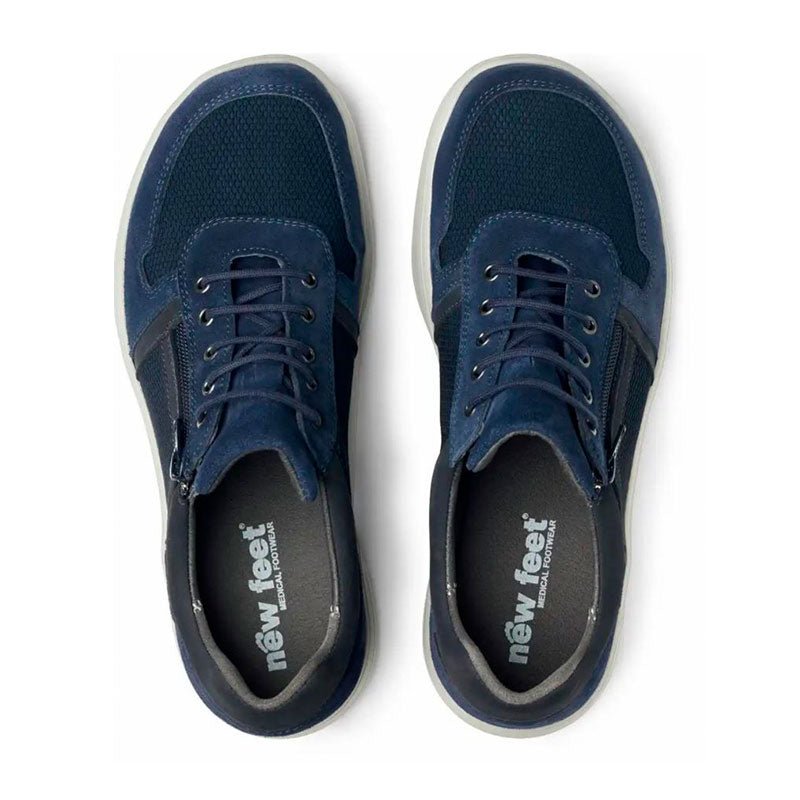 Ett par mörkblå New Feet herrsneakers sedda uppifrån, med synliga innersulor märkta "new feet"