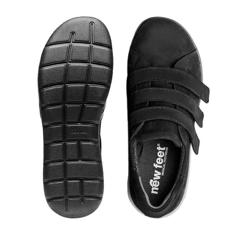En svart New Feet damsko i nubuck uppifrån bredvid en sula med mönster