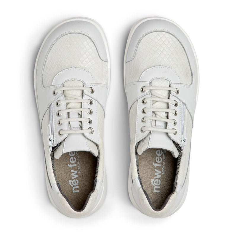 Vita New Feet damsneakers sedda uppifrån, visar innersulorna med logotyp och snörning