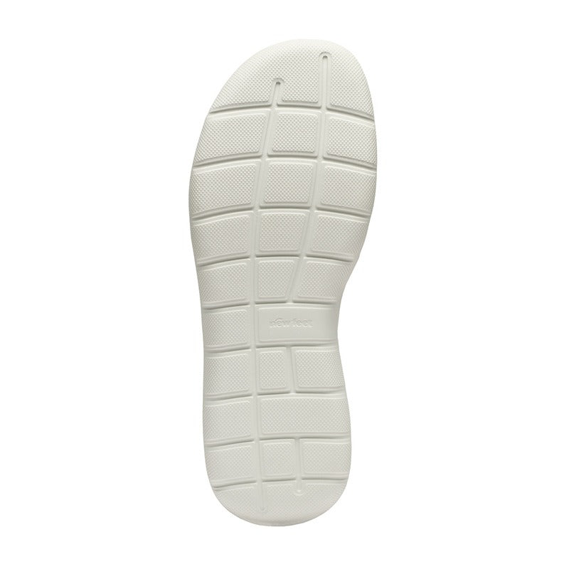 Den vita, stötdämpande yttersulan på en New Feet damsneaker med tydligt mönster