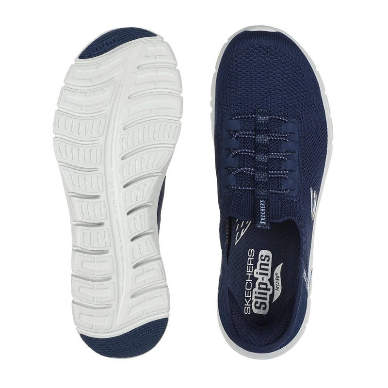 Ovanifrån syns en marinblå Skechers slip-in sko och dess vita sula med mönster