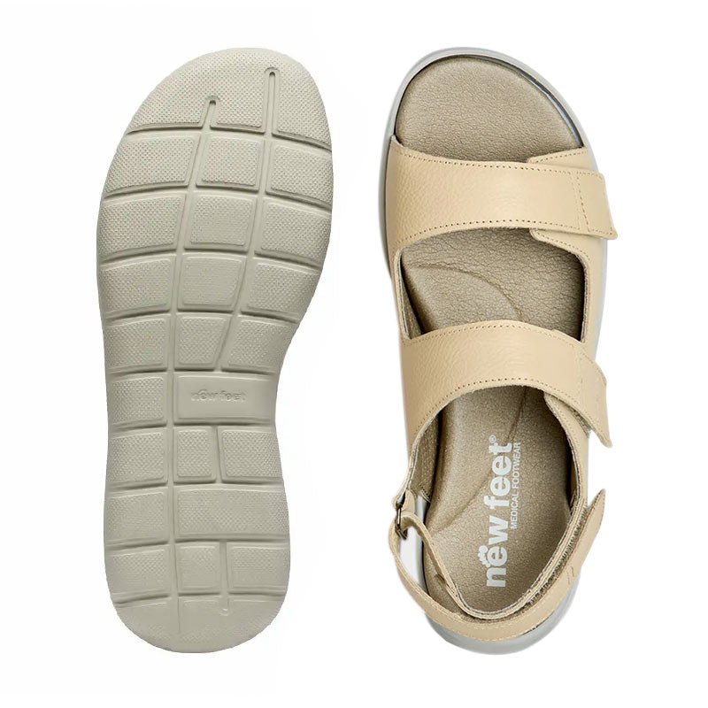 En New Feet damsandal sedd uppifrån med logotyp på innersulan, bredvid en matchande yttersula