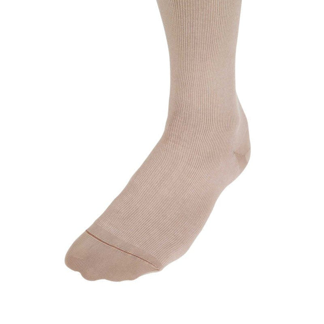 Närbild på fotdelen av en beige stödstrumpa med tydlig ribbad struktur och tåsöm
