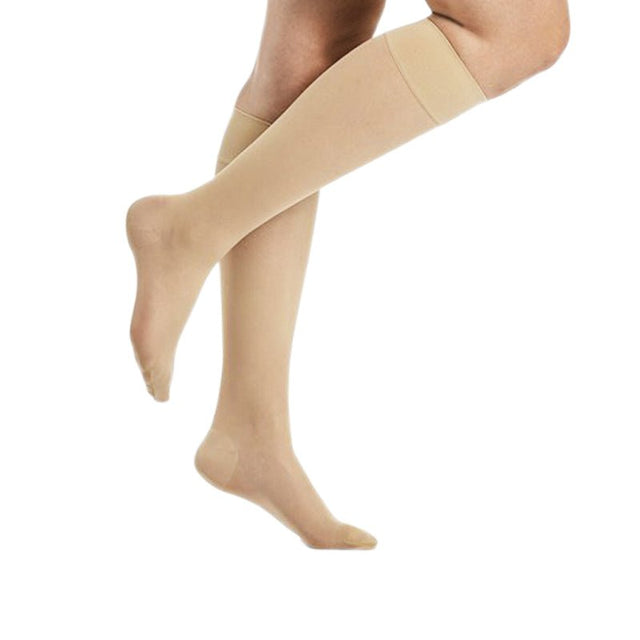 Beige Delilah knästödstrumpor på ben, syns från fot till knä, med en tunn och genomskinlig look