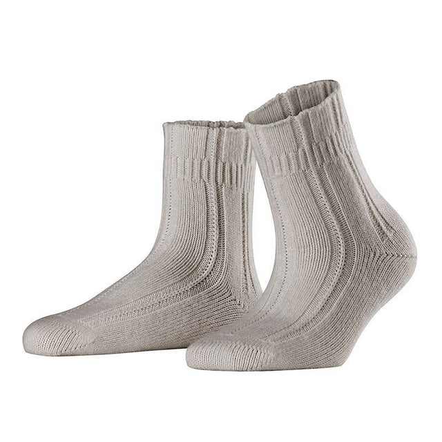 Ett par grå Falke nattsockor med angoraull, ribbstickade och mjuka, sedda snett framifrån
