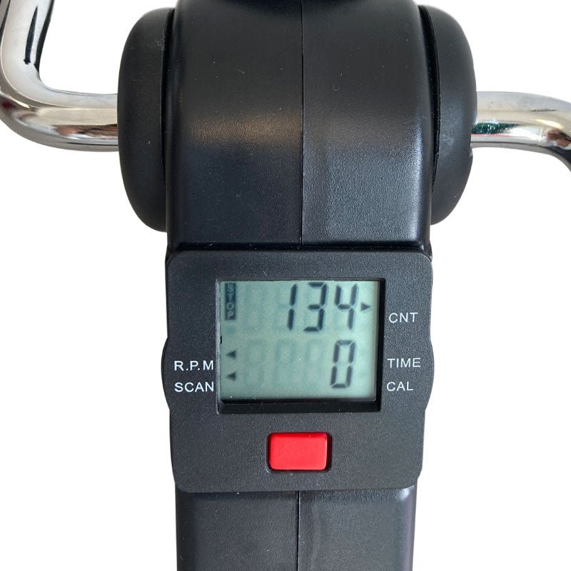 Närbild på pedaltränarens digitala display som visar träningsdata och en röd knapp