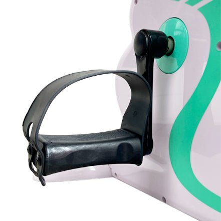 Närbild på en svart pedal med rem på den vita elektriska pedaltränaren