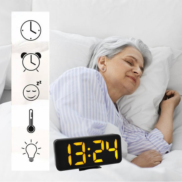 Ældre kvinde sover roligt i sengen med et sort vækkeur med store tal i forgrunden og funktionsikoner