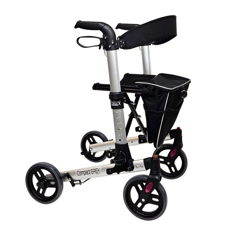 Silverfärgad aluminiumrollator med svart textilsäte, ryggstöd och avtagbar väska, sedd snett framifrån