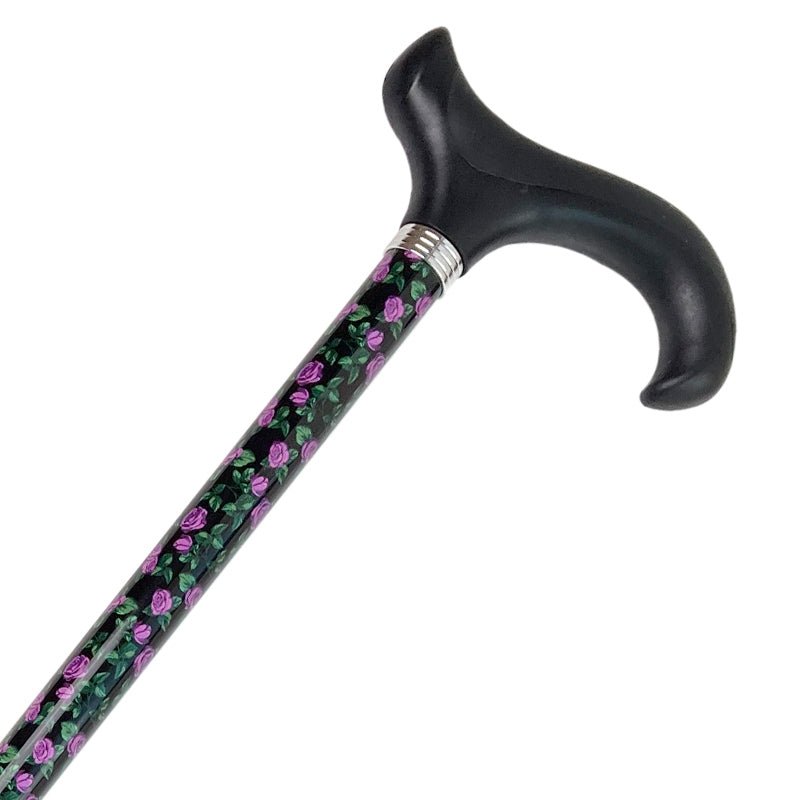 Svart justerbar käpp med ergonomiskt handtag och lila rosmönster på skaftet, nära bild