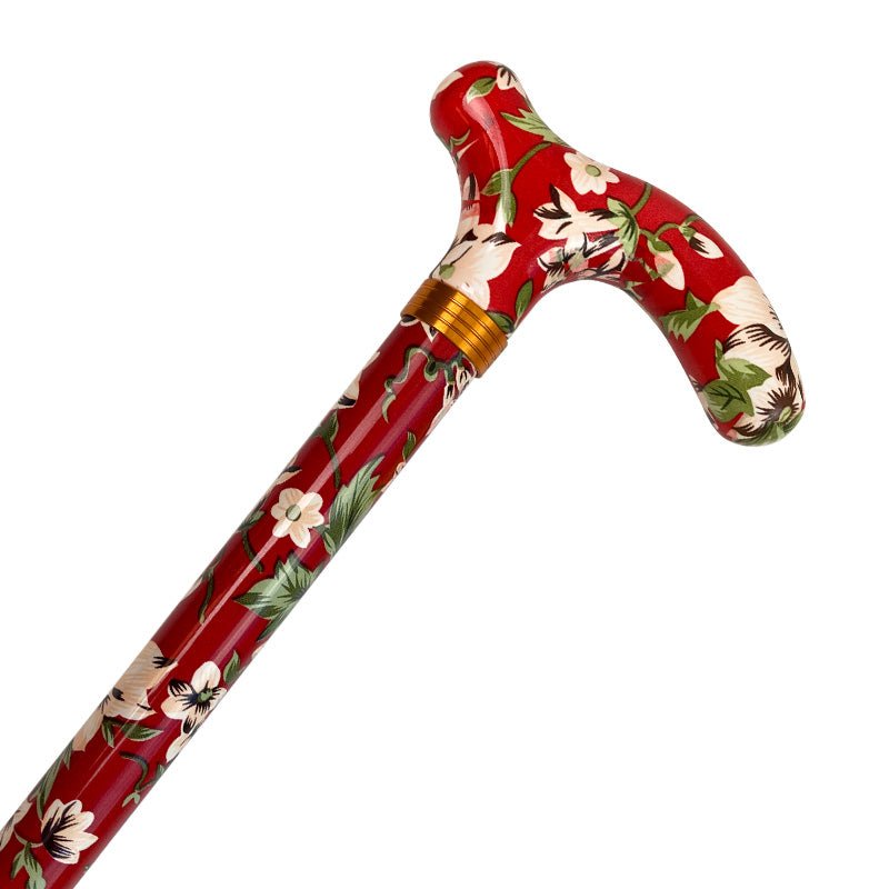 Rödblommig käpp med vitt blommönster och gröna blad, nära handtaget med guldfärgad ringdetalj