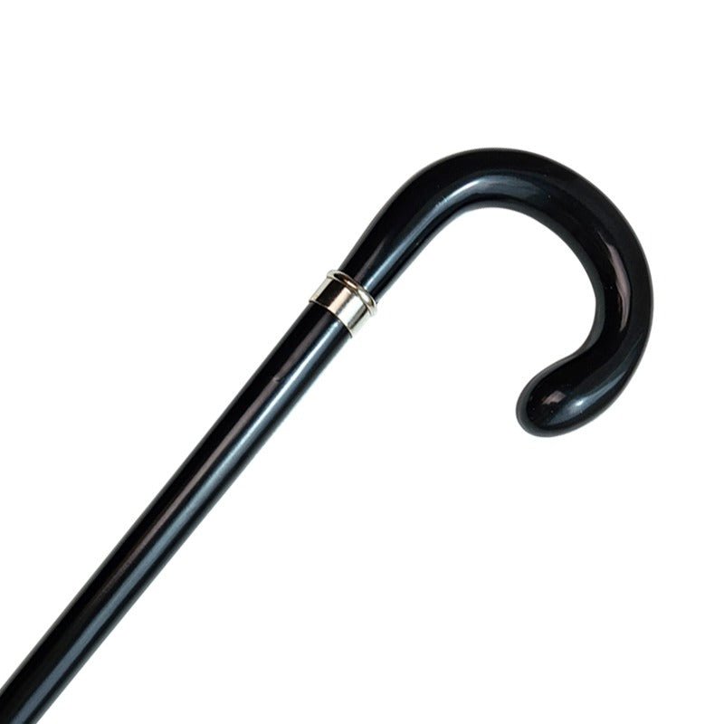 Närbild av den svarta promenadkäppen i trä med böjt handtag och dekorativ silverring