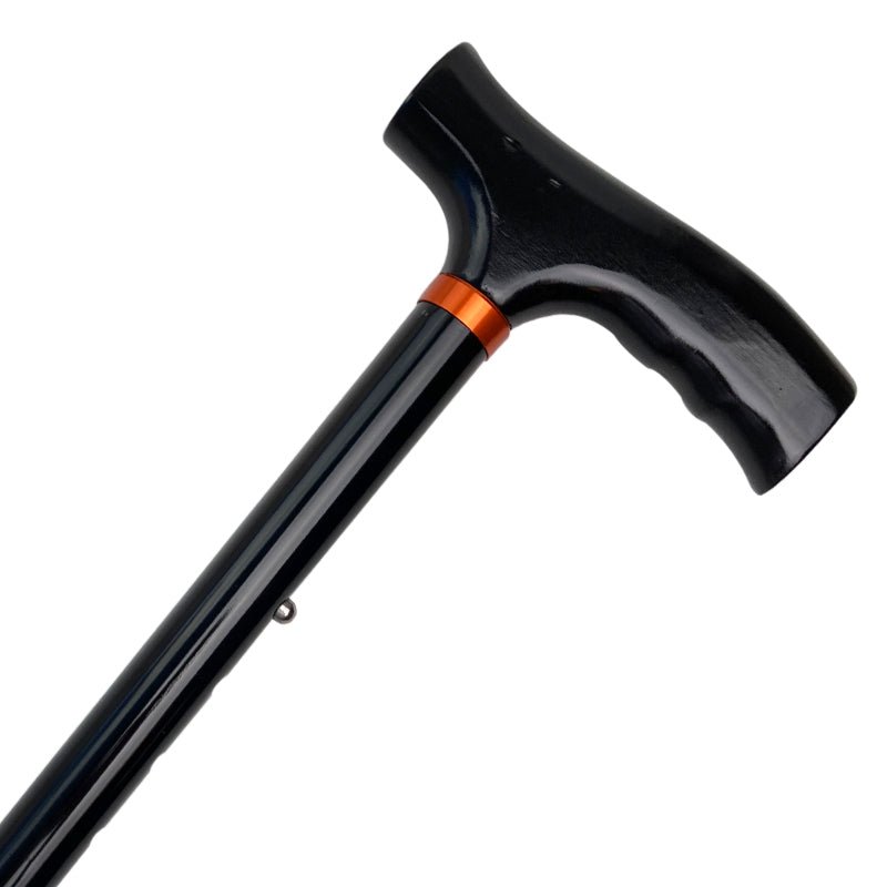 Svart hopfällbar käpp med ergonomiskt T-handtag i plast och en orange ring vid fogen, sett snett uppifrån