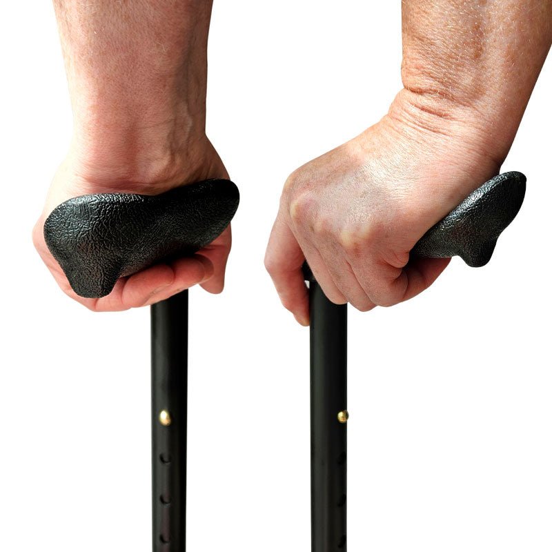 Två händer som håller i de ergonomiska handtagen för höger och vänster hand på en käpp