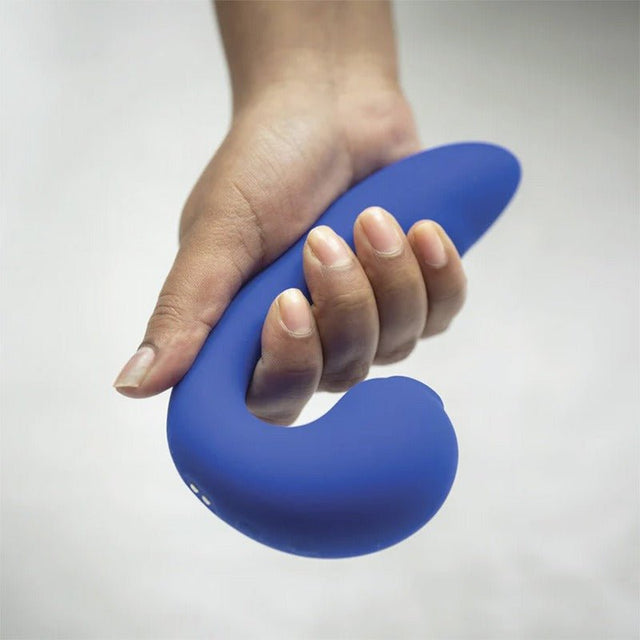 En hand håller den blå Iris vibratorn, som visar dess ergonomiska design och storlek