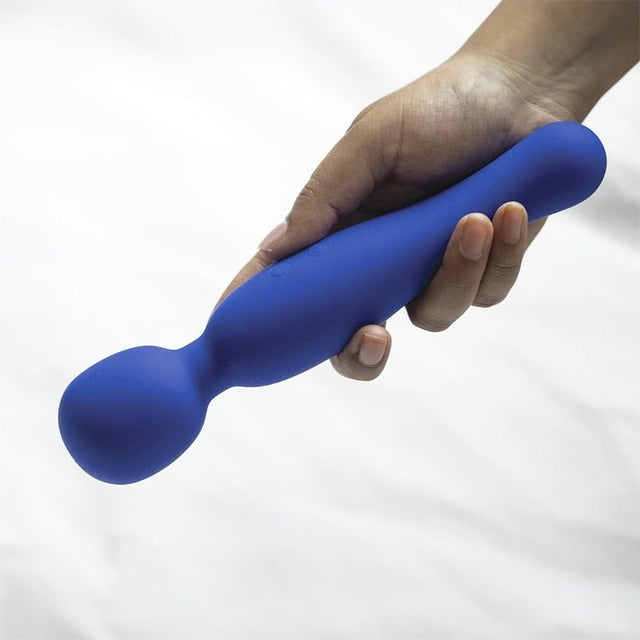 En hand håller den blå Wander vibratorn, som visar dess ergonomiska form och mjuka silikon
