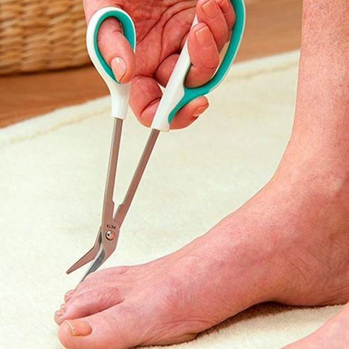 En hand använder en Peta tånagelsax med långt skaft för att klippa en tånagel på en fot