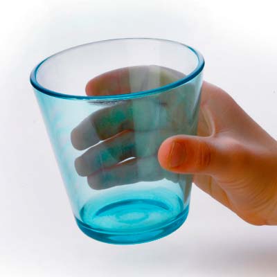 En hand håller ett blått plastglas i konisk form, vilket visar hur lätt det är att greppa