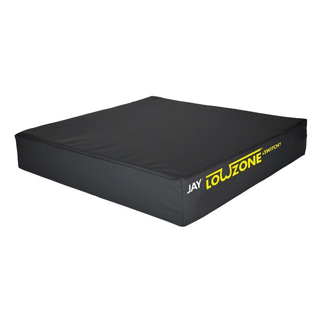 Svart LowZone Switch tryckavlastande sittdyna med gul logotyp, sedd snett framifrån