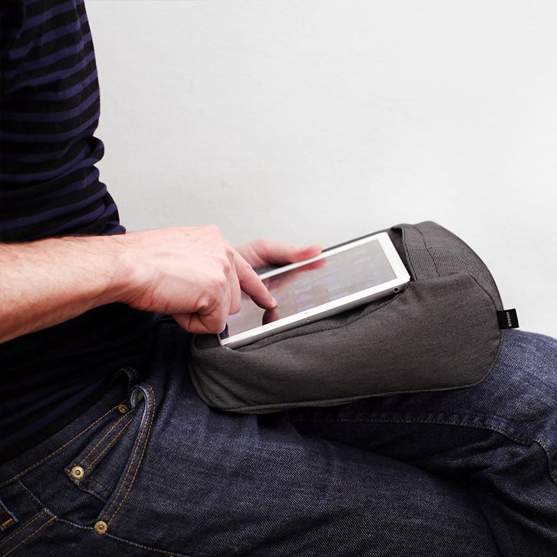 En person bruger den grå 2-i-1 holder på skødet til en tablet, mens de trykker på skærmen