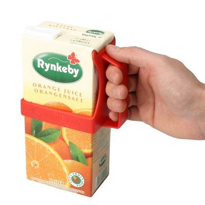 Röd kartonghållare som håller en juiceförpackning med apelsinjuice, en hand håller stadigt i handtaget