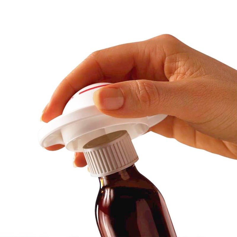 En hand använder den vita MultiGrip skruvlocksöppnaren för att öppna en medicinflaska med vitt skruvlock