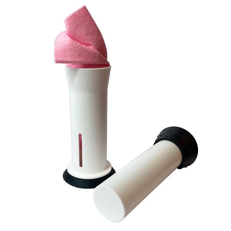 Vit disktrasepress i två delar, med en rosa disktrasa i den ena cylindern, sedd framifrån